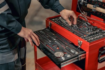 Close up of man maintenance technician grabbing wrench from instrument box set